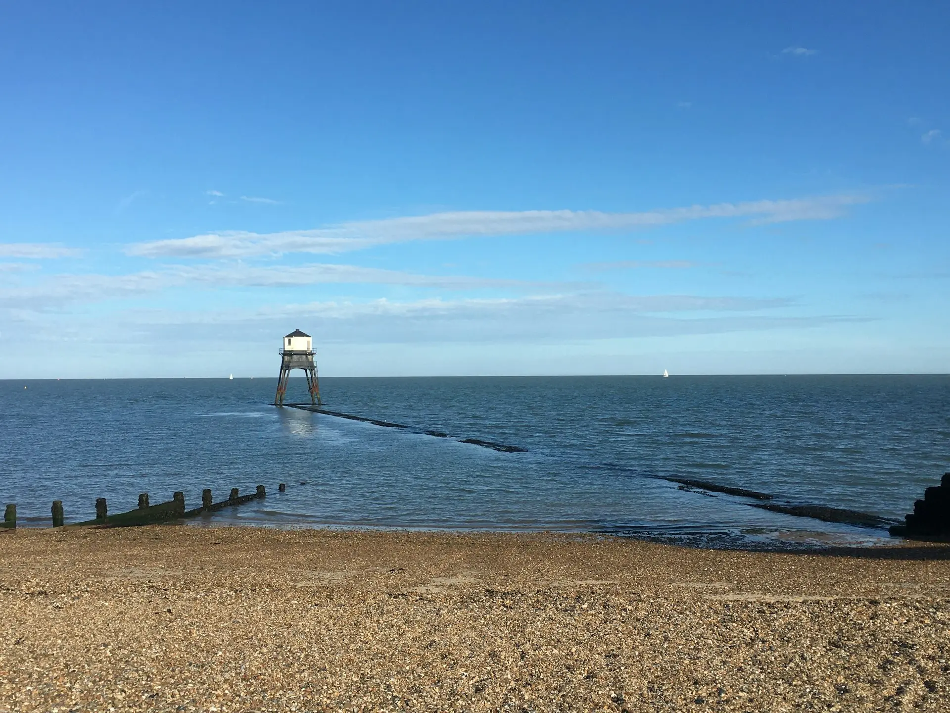 person standing on dock near sea during daytime